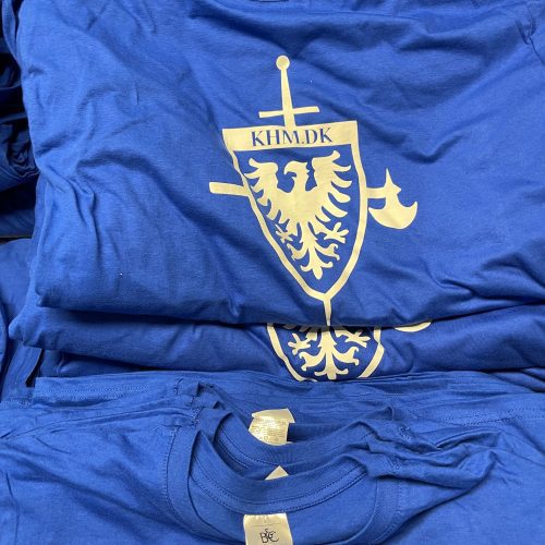 Blå tshirts der er foldet pænt sammen med at logo trykt på maven